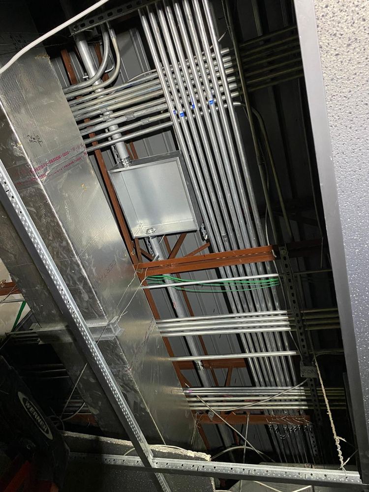 Overhead EMT conduit runs and junction boxes installed during commercial rough-in