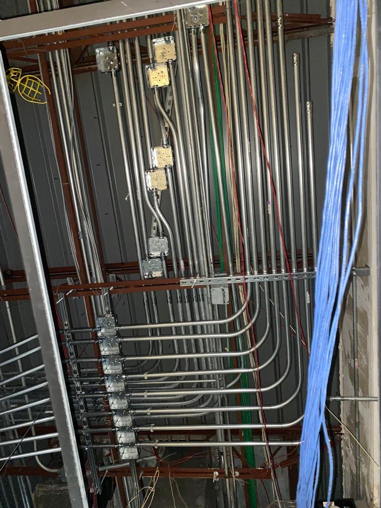 Junction boxes and conduit bends routed through a ceiling grid