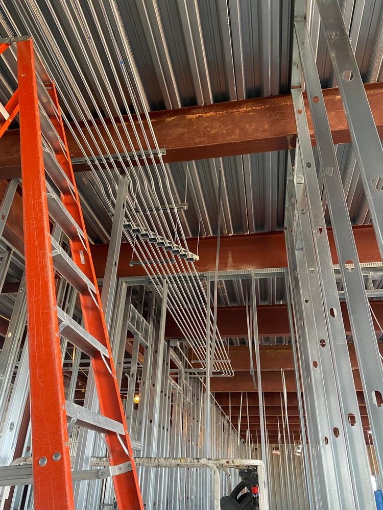 Overhead electrical conduit installation in an open commercial ceiling